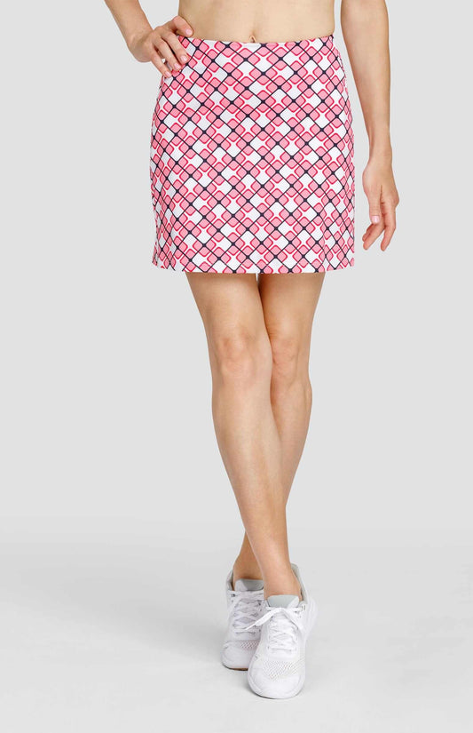 Bottom half of a woman wearing a pull-on skort with a light pink and white geometric print with dark navy blue lines.